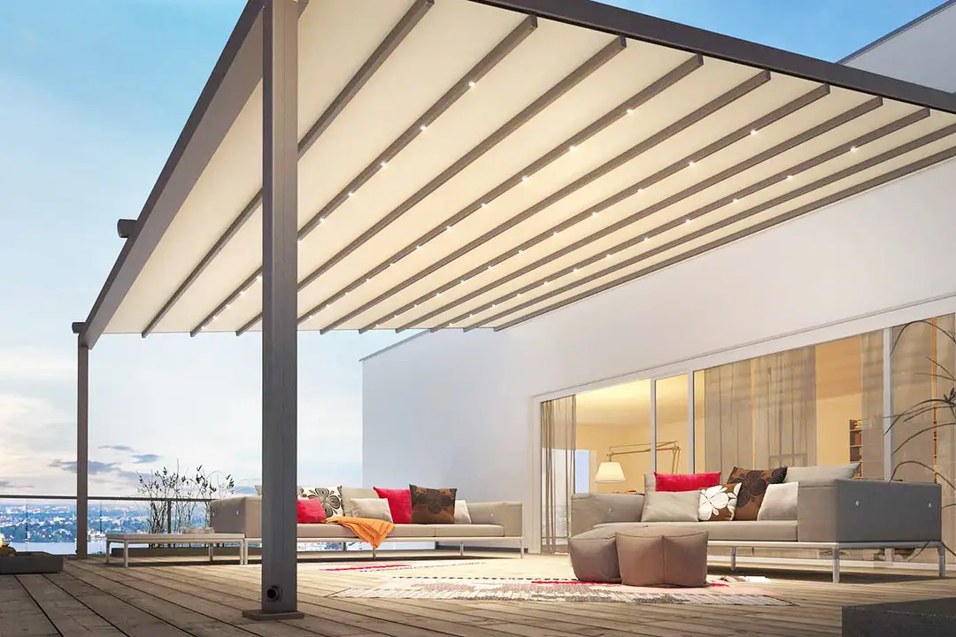 Retractable pergola awning shading a terrace lounge at dusk